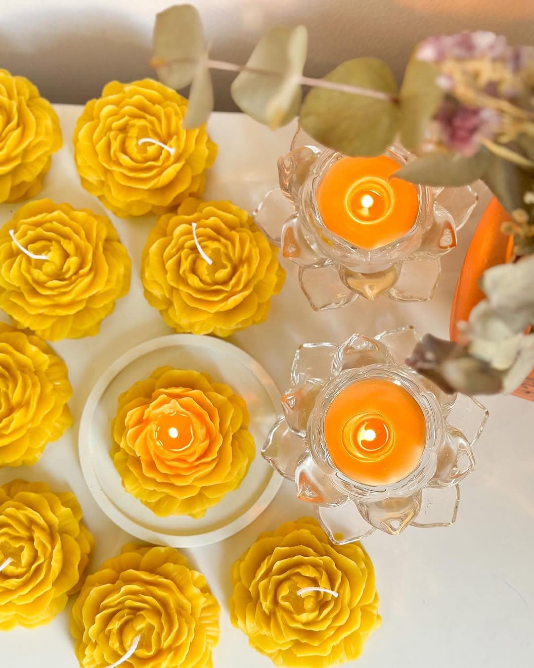 Bloom, rose-shaped beeswax candles with lit lotus tealights