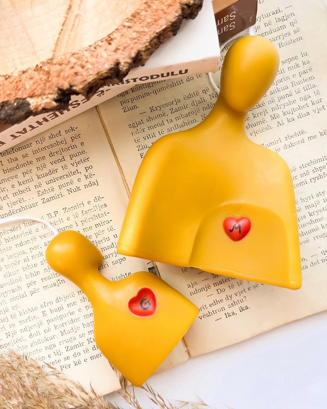 Embrace, a pair of beeswax figures with red heart accents